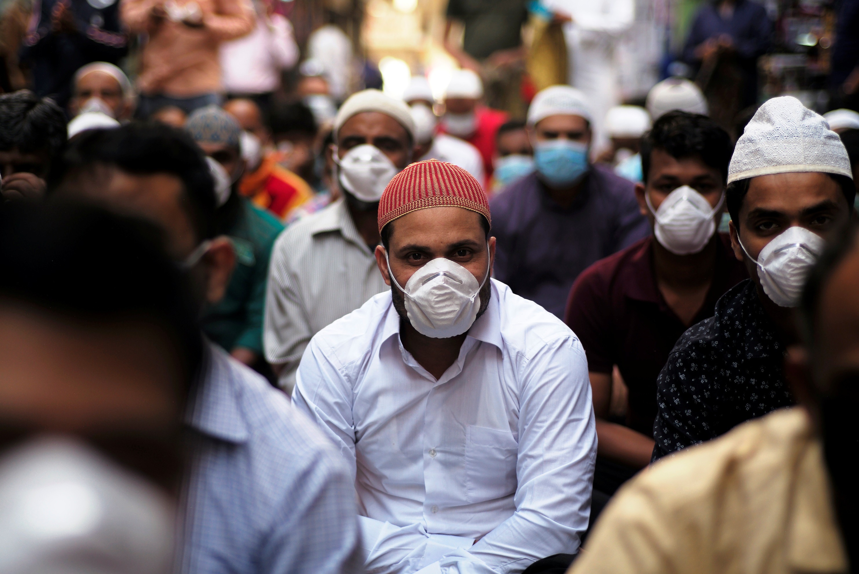 Muslims wear protective face masks following the coronavirus outbreak, as they pray on street during Friday prayers in local souq, in Manama
