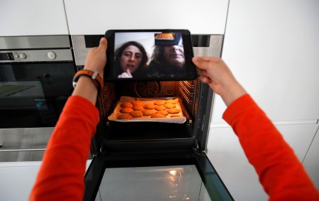 Criança faz biscoitos seguindo orientações dos pais via chamada de vídeo