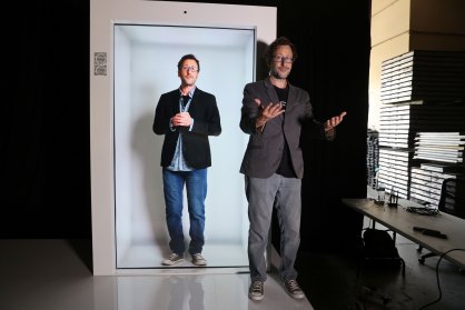 David Nussbaum ao lado de uma máquina com seu holograma