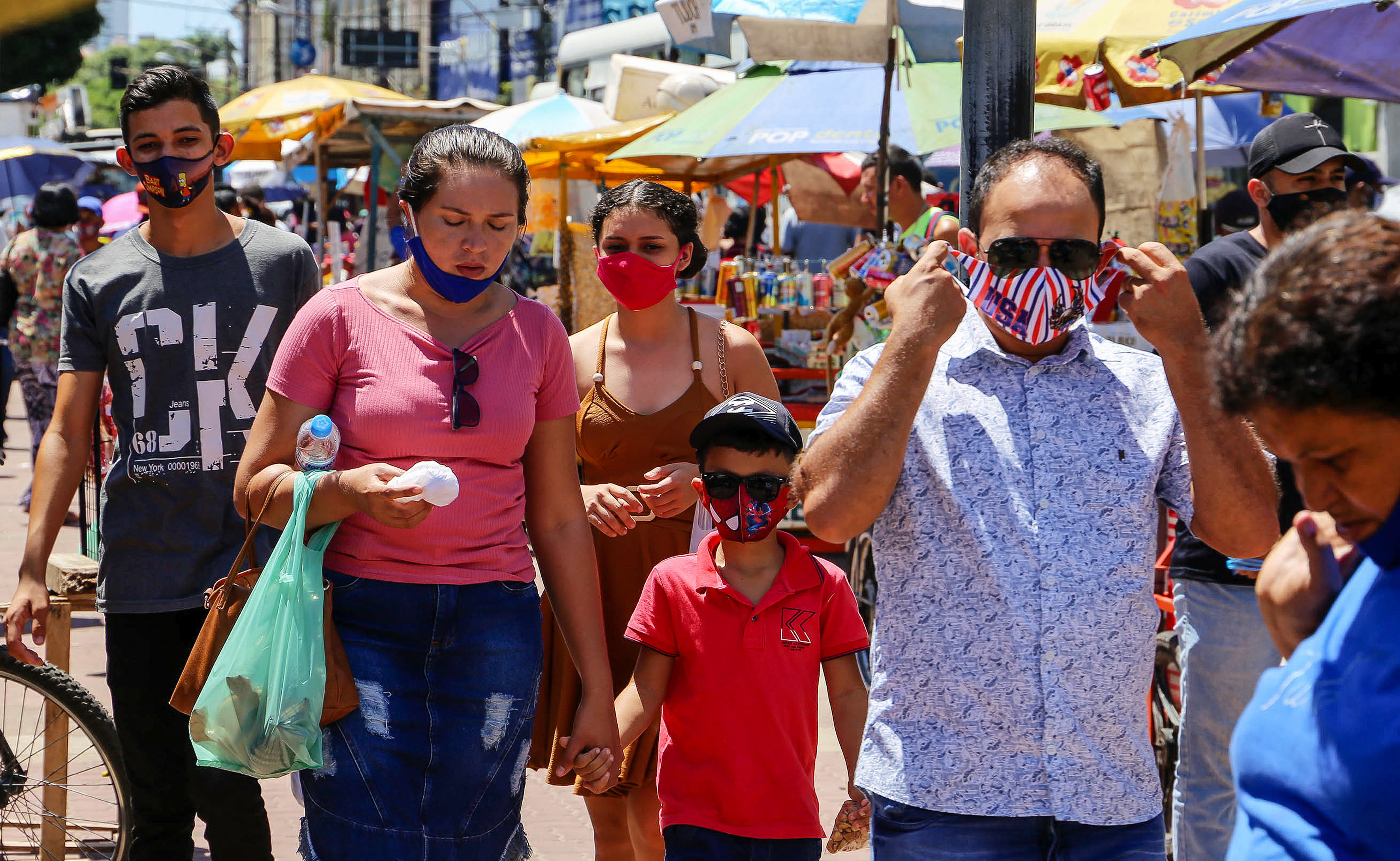 Pessoas nas ruas com e sem máscaras