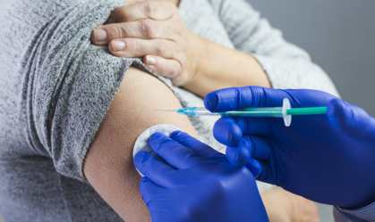 Enfermeira aplicando vacina em braço