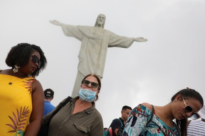 Turista usa máscara durante visita ao Cristo Redentor, no Rio de Janeiro