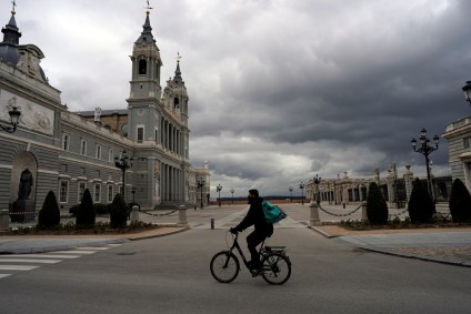 Entregador passa por praça vazia em Madri após quarentena por coronavírus