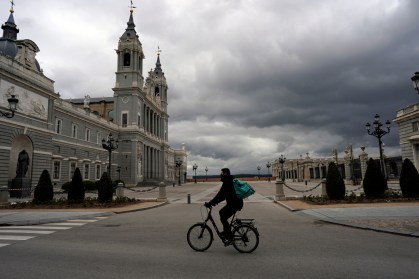 Entregador passa por praça vazia em Madri após quarentena por coronavírus