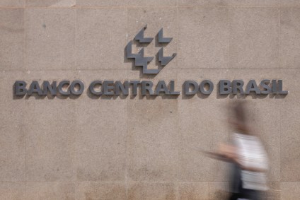 Pessoa caminha em frente a letreiro do Banco Central