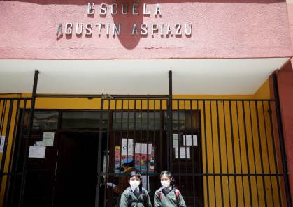 Alunas usam máscaras em frente à escola em La Paz, Bolívia
