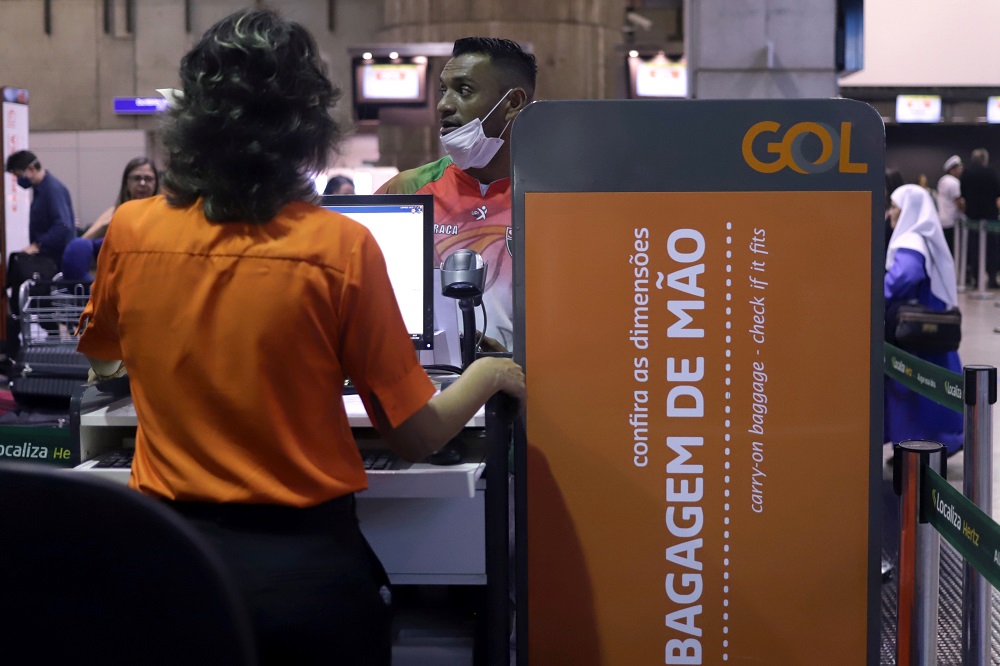Homem usa máscara de proteção durante check in em balcão da Gol