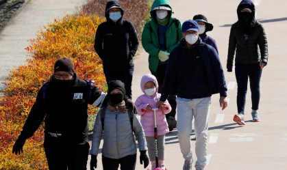 Família caminha em Daegu, na Coreia do Sul, usando máscaras