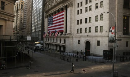 Homem caminha pela Wall Street, em Nova York