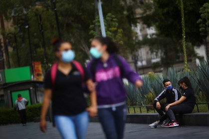 Pessoas utilizam máscara de proteção enquanto conversam em praça no México