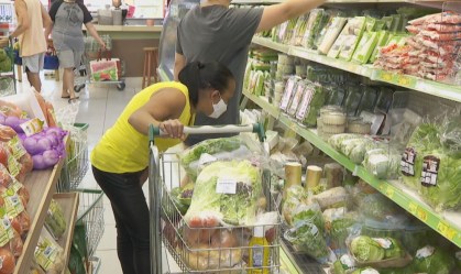Mulher escolhe produtos em supermercado em São Paulo