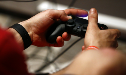 Jogador com o controle do PlayStation 4, da Sony