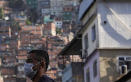 Homem espera ônibus na favela da Rocinha, no Rio de Janeiro