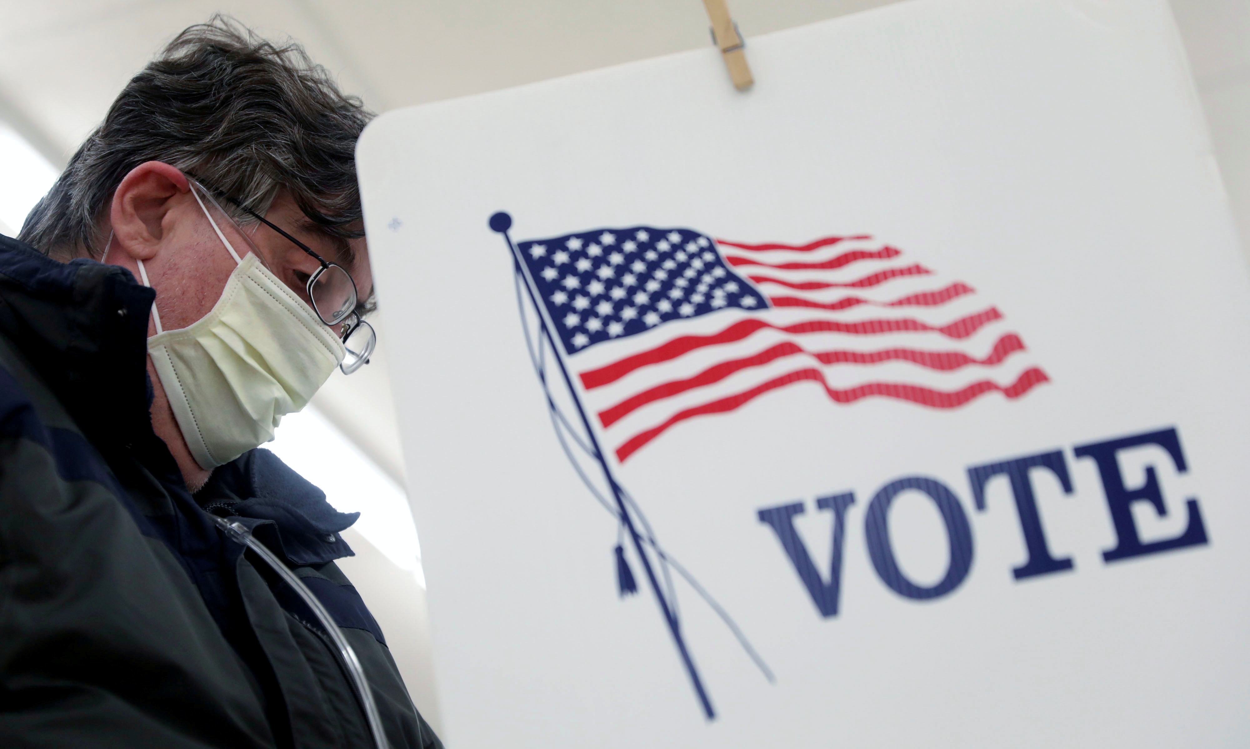 Eleitor vota usando máscara de proteção contra coronavírus