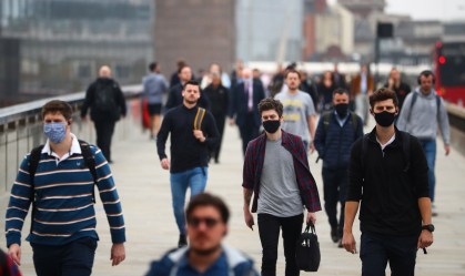 Pessoas andando de máscara nas ruas