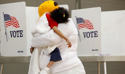 Com a filha no colo, mulher vota na eleição presidencial dos EUA, em 2016