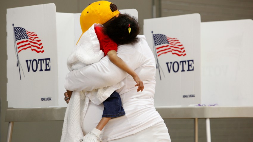 Com a filha no colo, moradora da Carolina do Norte vota na eleição presidencial dos EUA, em 2016 / Foto: Jonathan Drake - 8.nov.2016/Reuters