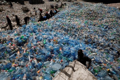 Empregados manipulam embalagens numa fábrica de reciclagem
