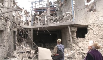 Moradores de Stepanakert, no Azerbaijão, caminham em meio a escombros