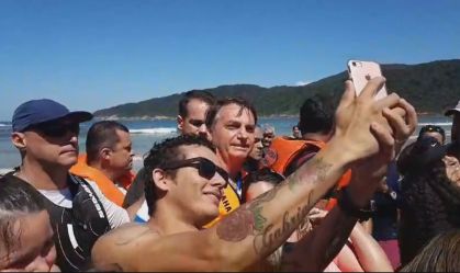 Bolsonaro passeia e tira foto com apoiadores em praia do litoral paulista
