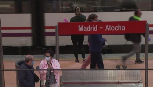 Pessoas usam máscara e álcool gel em rua na Espanha