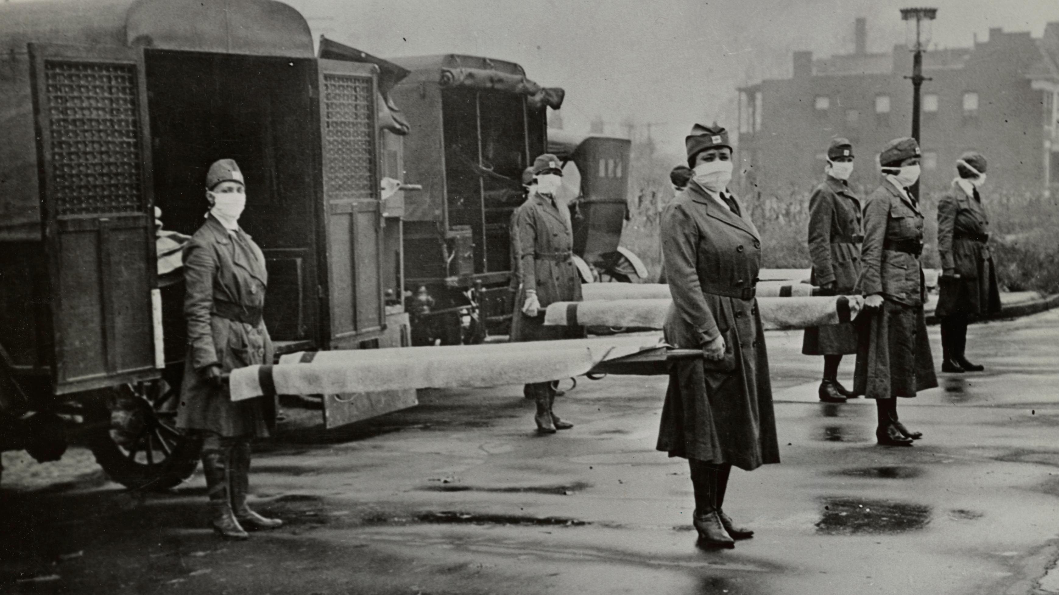 Mulheres usando máscaras seguram macas durante a gripe espanhola, em 1918.