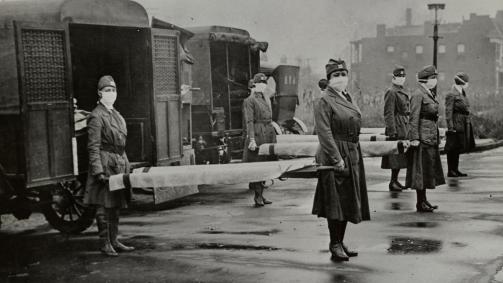 Mulheres usando máscaras seguram macas durante a gripe espanhola, em 1918.