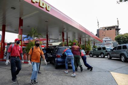 Pessoas empurram carro sem combustível até posto