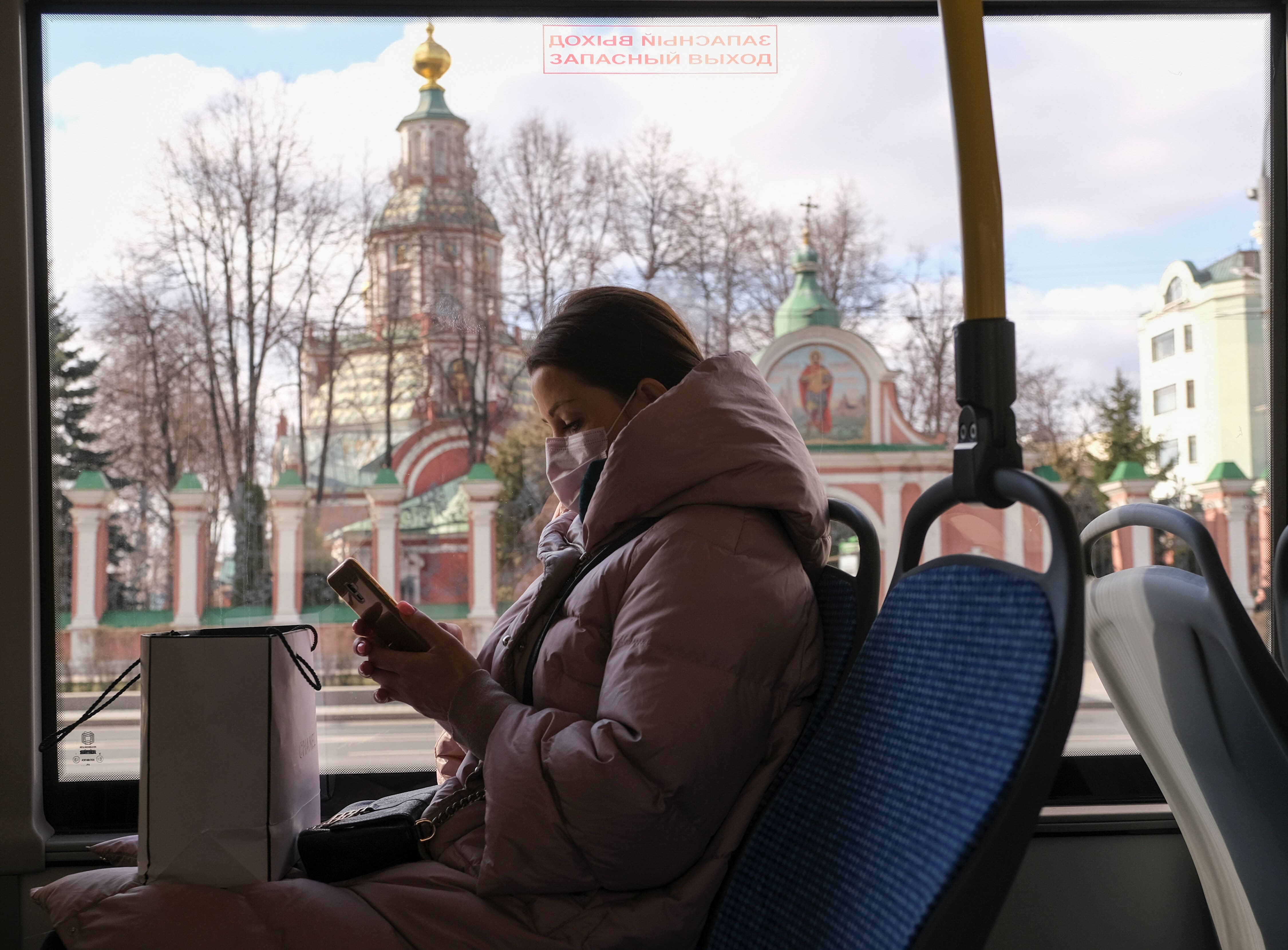 Mulher em ônibus de máscara