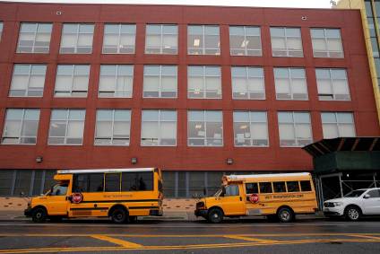 Ônibus escolares estacionados em frente a uma escola no Brooklyn, em Nova York