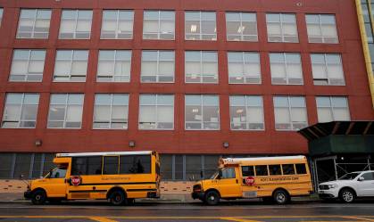 Ônibus escolares estacionados em frente a uma escola no Brooklyn, em Nova York
