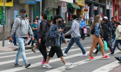 Pessoas caminham de máscara em Curitiba em meio à pandemia de Covid-19