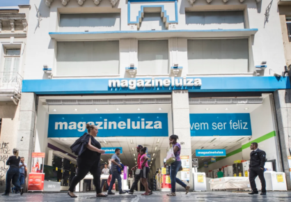 Pessoas caminhando em frente loja da Magazine Luiza