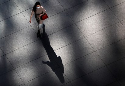 Mulher caminha de máscara pelo centro de Tóquio, no Japão