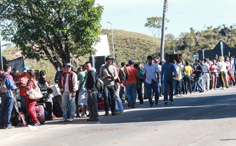 Imigrantes venezuelanos cruzam a pé a fronteira entre Venezuela e Brasil, próximo ao município de Pacaraima, em Roraima. / Foto: Wherter Santana/AE (19.abr.2018)