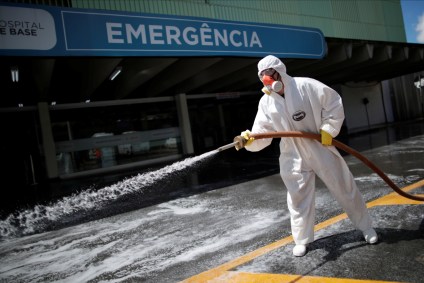 Funcionário limpa entrada da emergência de hospital em Brasília