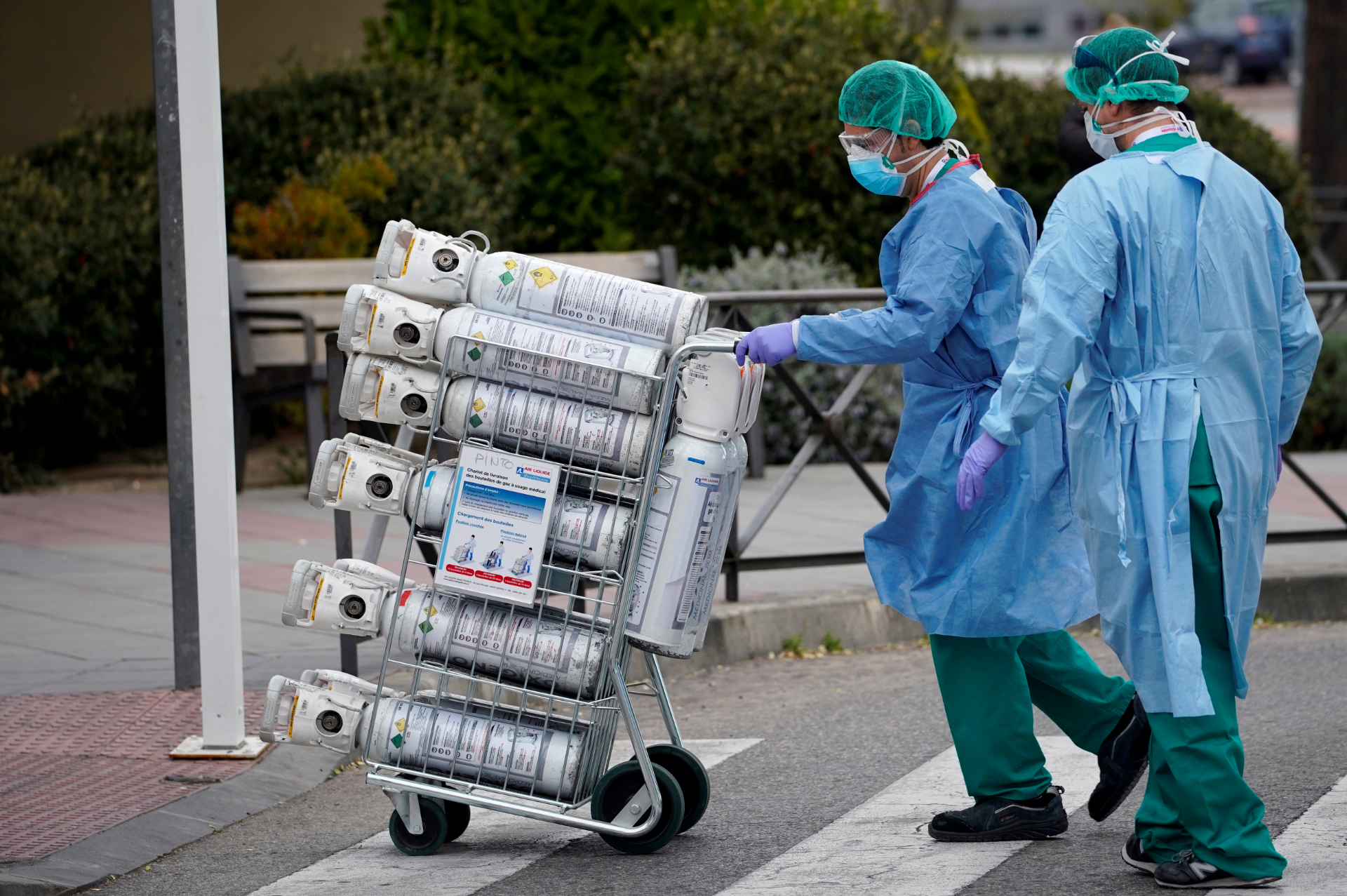 Funcionários carregam cilindros de oxigênio em hospital de Madri