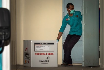 Funcionário transporta caixa com vacinas da Sinovac contra Covid-19 em Semarang