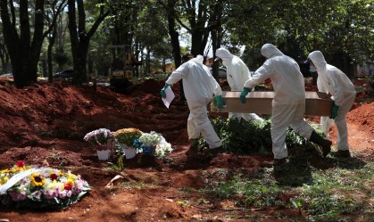 Coveiros usam trajes de proteção no cemitério de Vila Formosa, em São Paulo