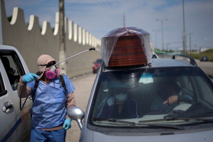 Equatoriano passa desinfetante em carro com caixão de vítima de COVID-19