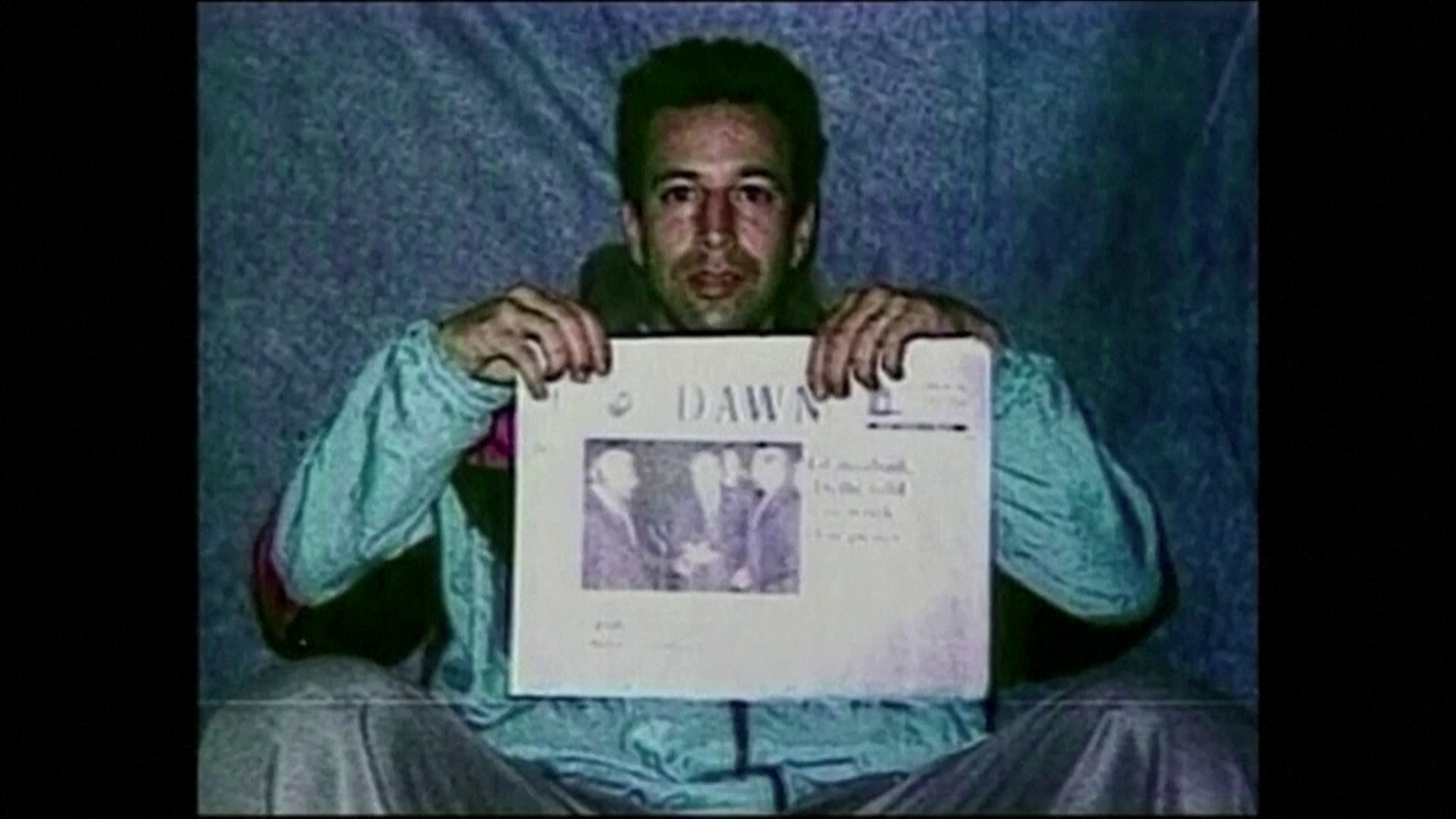 Daniel Pearl segura jornal em imagem divulgada por sequestradores em 2002