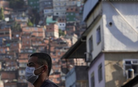 Homem usa máscara protetora na Rocinha, no Rio de Janeiro