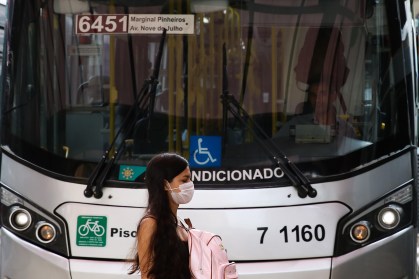 Transeunte usa máscara protetora em terminal de ônibus em São Paulo