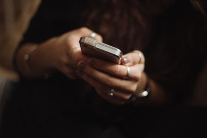 Mulher com celular na mão