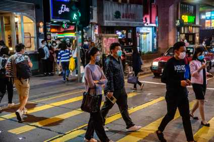 Pedestres usam máscaras em cruzamento em Hong Kong