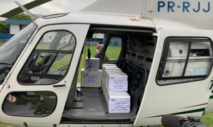 Helicóptero com doses de vacina