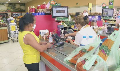 Consumir e caixa de supermercados usando máscaras de proteção contra a Covid-19