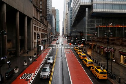 Um homem atravessa uma rua vazia no centro de Manhattan em meio à pandemia