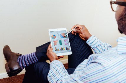 Homem analisa planilha com dados (investimento, cursos)