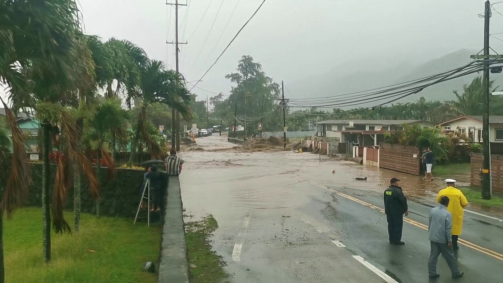 Moradores de Hauula, em Honolulu, observam rua inundada após fortes chuvas